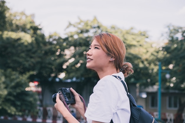 都市の写真を撮っているカジュアルな女性