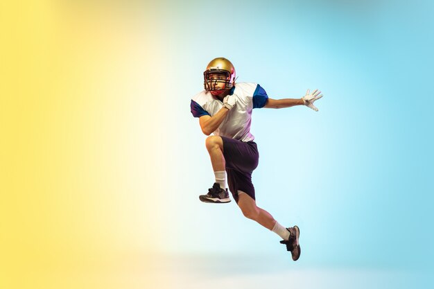 Catching. American football player isolated on gradient in neon light.