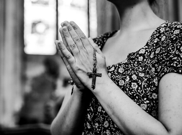 Catholic woman praying with a rosary at the church