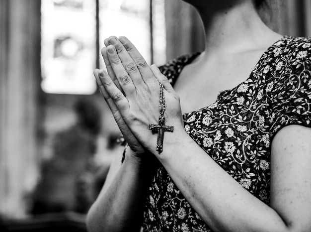 Католическая женщина молится с розарием в церкви