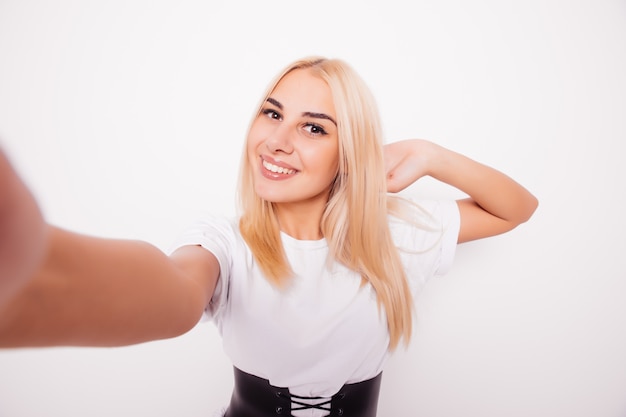 白人の美しさのブロンドの女性がselfieを取る