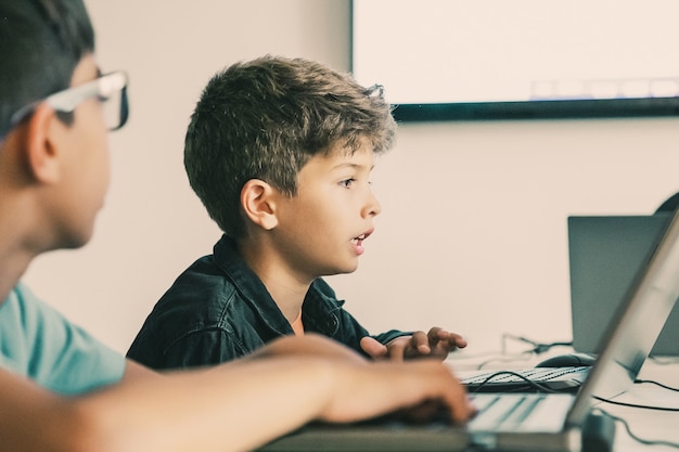 Caucasian boy reading task aloud during lesson