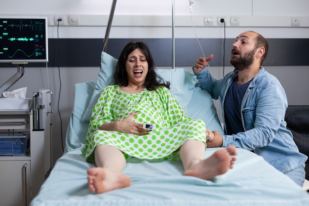 병원 병동 침대에서 아기를 기대하는 백인 부부