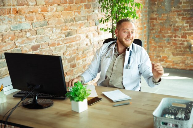 Caucasian doctor consulting for patient, working in cabinet