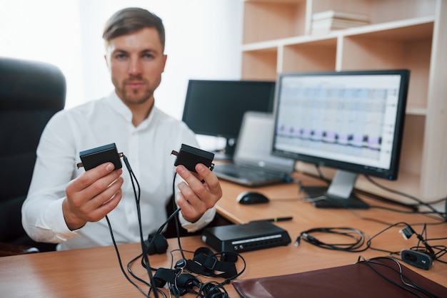 Caucasian ethnicity. Polygraph examiner works in the office with his lie detector's equipment