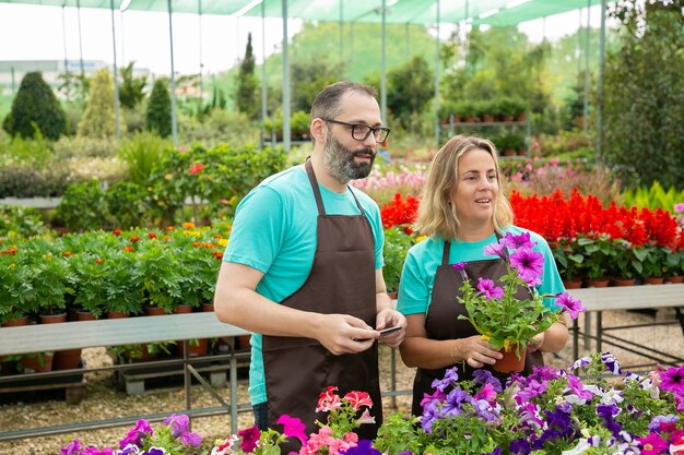 Caucasian farmers standing in greenhouse and looking away