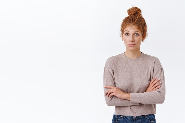 caucasian female with curly hair in bun, crossing arms over chest