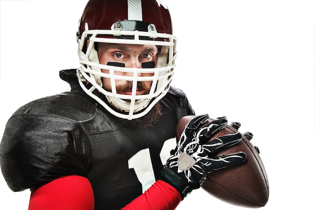 Caucasian fitness man as american football player holding a ball on white background