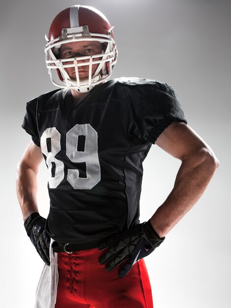 Caucasian fitness man as american football player on white
