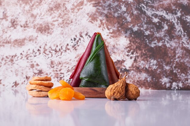 Caucasian fruit lavash in a wooden platter with dry fruits on white background. High quality photo