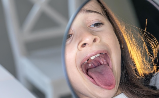 Foto gratuita ragazza caucasica con le parentesi graffe sui denti guardando lo specchio