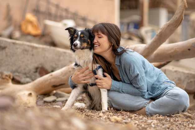 Caucasian girl with her border collie dog on the beach and smiling