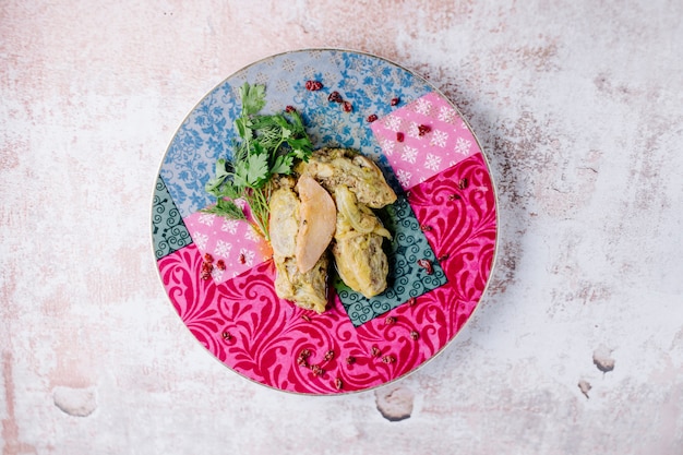 Caucasian khingali with parsley and apple slice in a colorful plate.