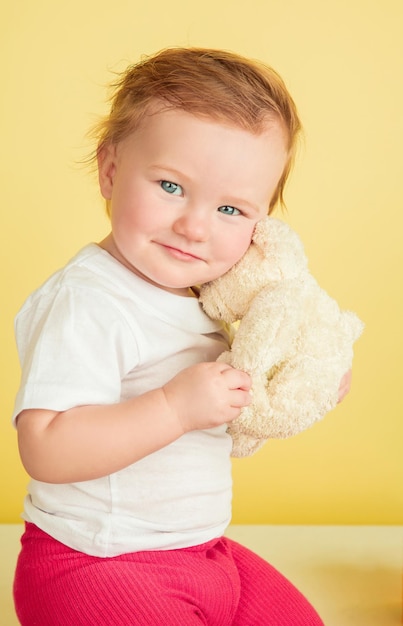 백인 어린 소녀, 노란색 스튜디오 배경에 고립 된 어린이. 귀 엽 고 사랑스러운 아이, 아기 재생 및 미소의 초상화.