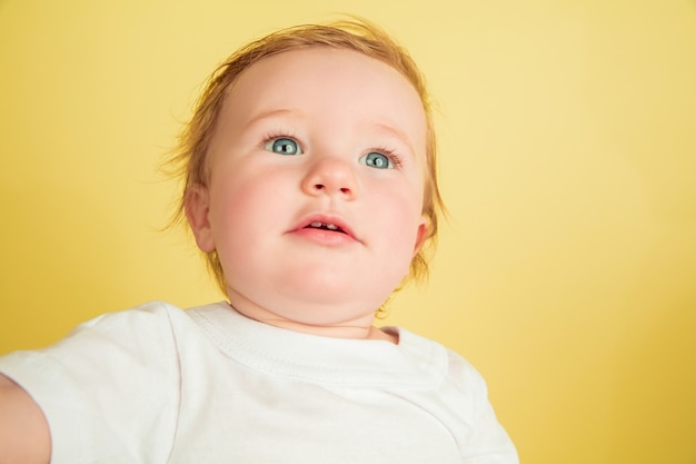 Free photo caucasian little girl, children isolated on yellow studio