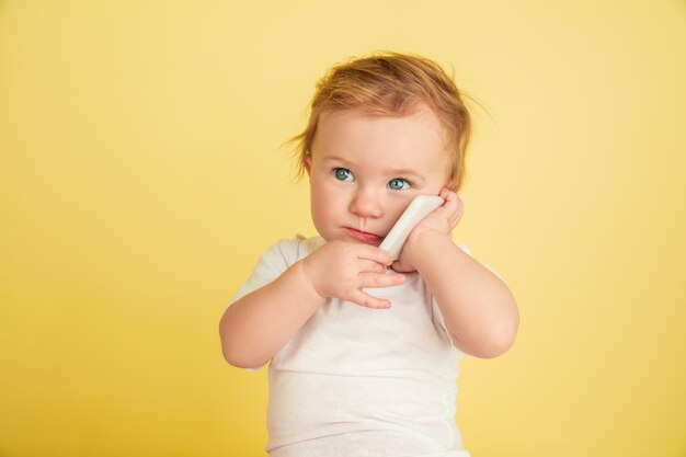 Caucasian little girl, children isolated on yellow