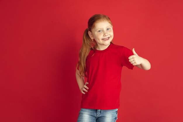 Caucasian little girl portrait isolated on red wall
