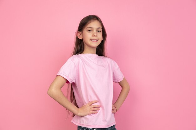 Caucasian little girl portrait on pink wall