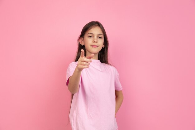 Caucasian little girl portrait on pink wall