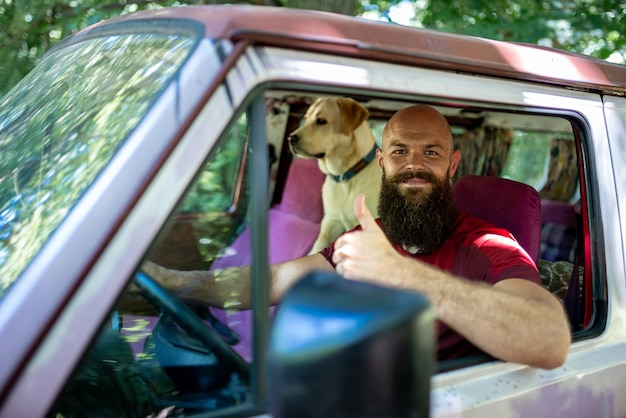 Caucasian male in a car with his Golden Retriever