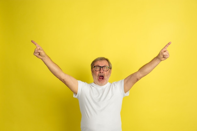 Caucasian man celebrating victory isolated on yellow