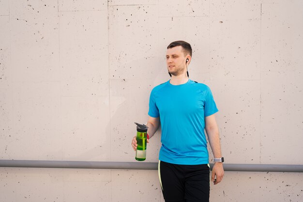 Free photo caucasian man drinking water during exercises