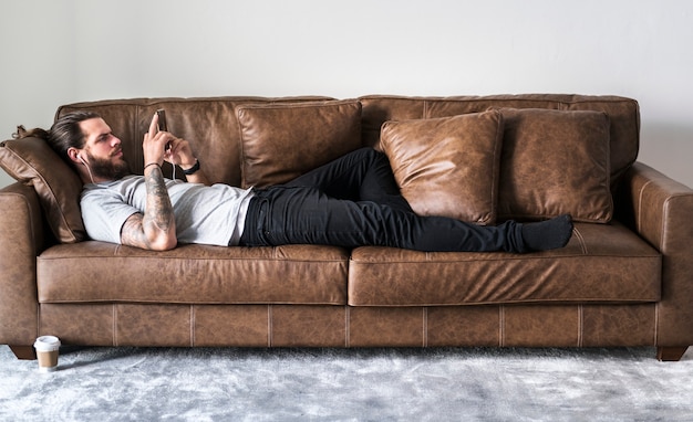 caucasian man listening to music on a couch