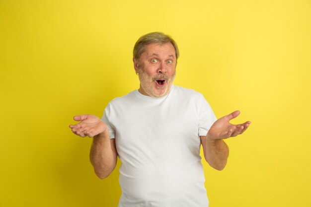 Caucasian man making inviting gesture on yellow