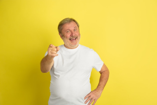 Caucasian man pointing, choosing you on yellow