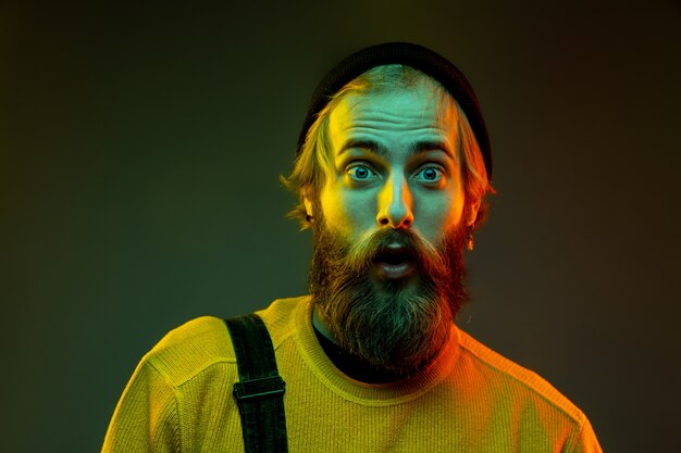 Caucasian man's portrait isolated on gradient studio background in neon light