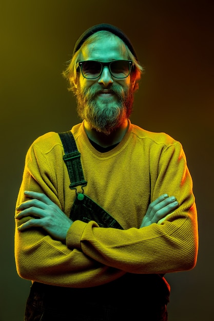 Caucasian man's portrait isolated on gradient studio in neon light