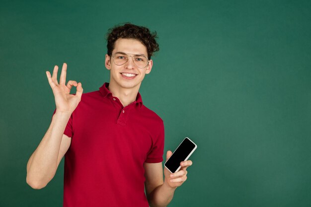 Caucasian man's portrait isolated on green studio background with copyspace