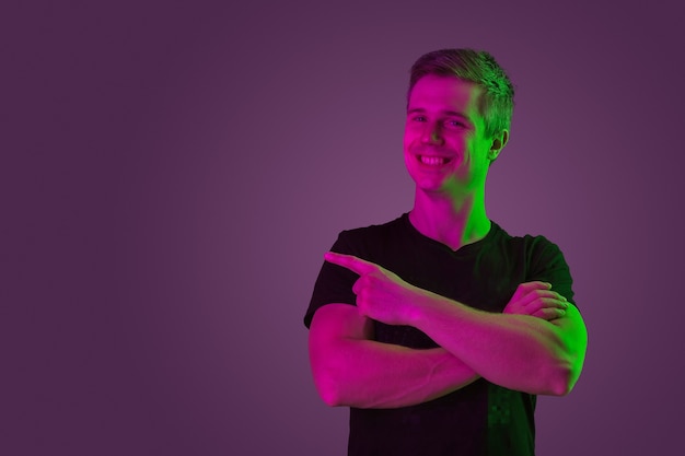 Free photo caucasian man's portrait isolated on purple studio in neon light
