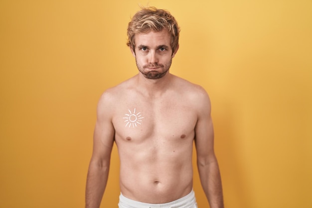 Caucasian man standing shirtless wearing sun screen puffing cheeks with funny face mouth inflated with air crazy expression