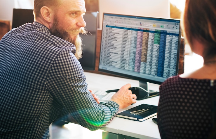 Free Photo caucasian man using computer talking with colleague