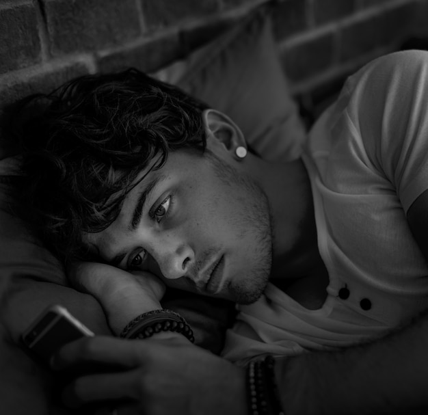 Caucasian man using mobile phone in bed