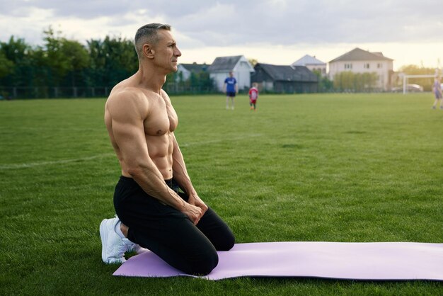 屋外で筋肉の体のトレーニングをしている白人男性