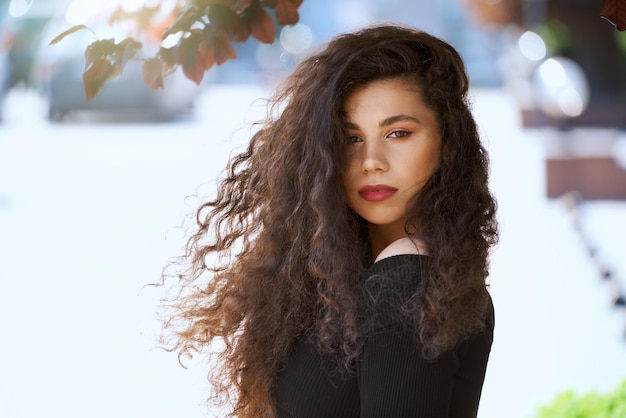 Free photo caucasian model posing under tree in city