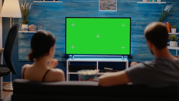 Caucasian people enjoying green screen layout on tv