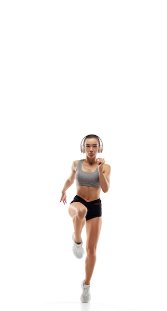 Caucasian professional female runner, athlete training isolated on white studio