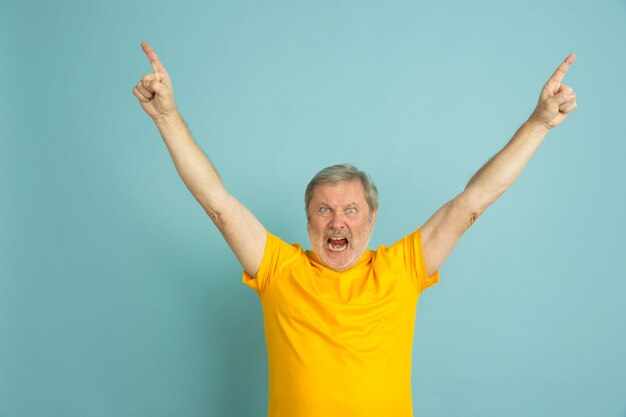 Caucasian senior man's portrait isolated on blue studio