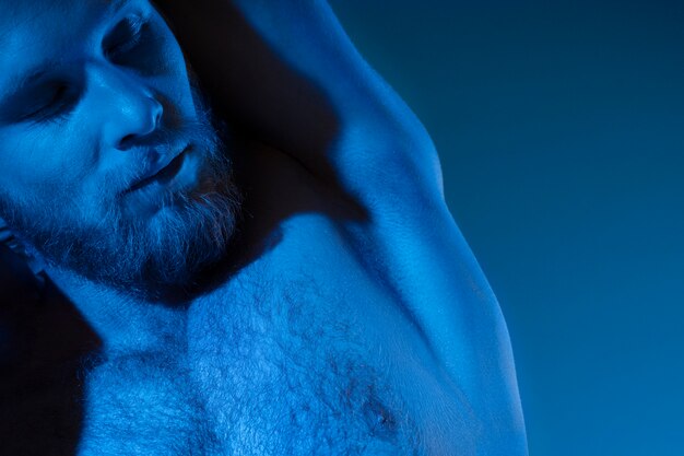 Caucasian shirtless man in blue tones