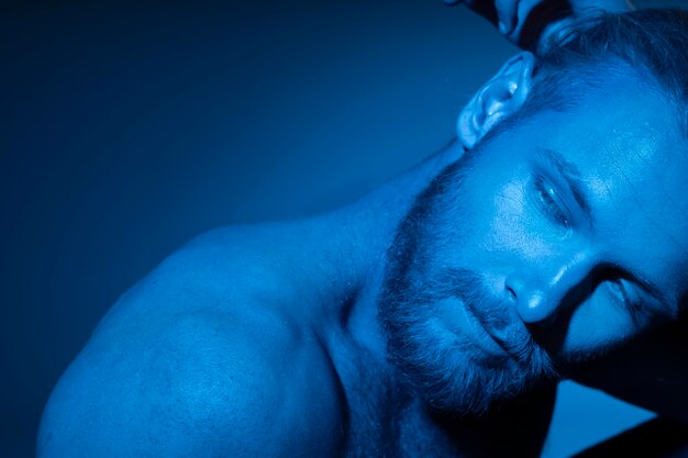 Caucasian shirtless man in blue tones