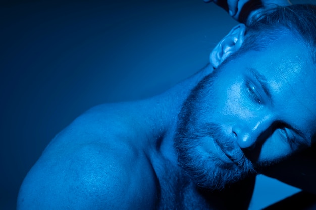 Caucasian shirtless man in blue tones