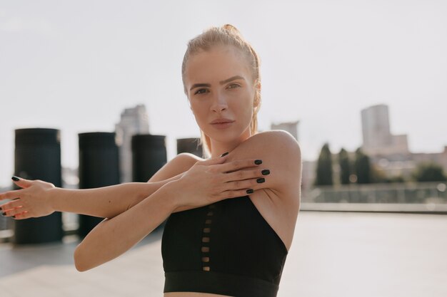 caucasian sportswoman doing exercise while working out on sports ground. High quality photo