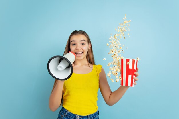 Caucasian teen girl portrait isolated on blue studio wall