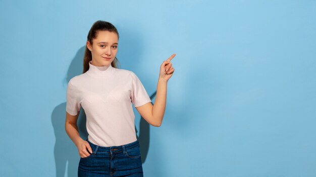 Caucasian teen girl portrait isolated on blue studio