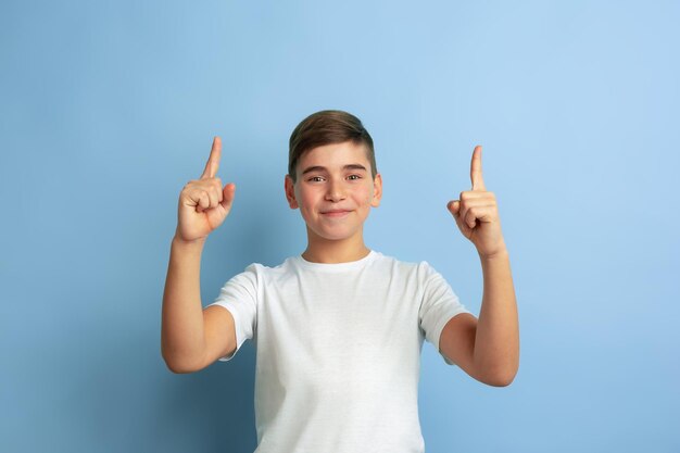 Caucasian teen's portrait isolated on blue studio