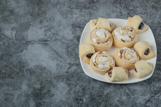 Caucasian traditional cookies with sugar powder on top on white ceramic plate.