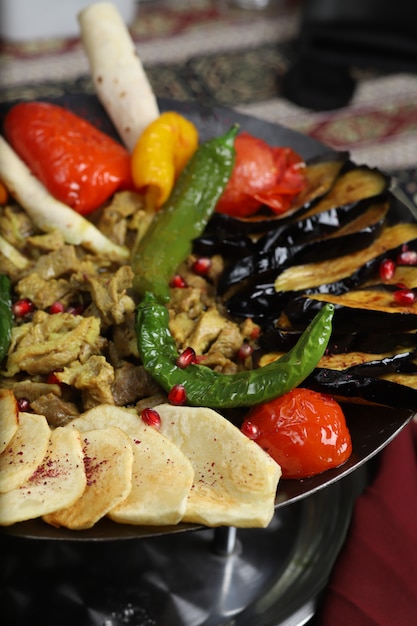 Caucasian traditional sac ici with fried potato, eggplant slices, tomatoes, pepper and beef stew   